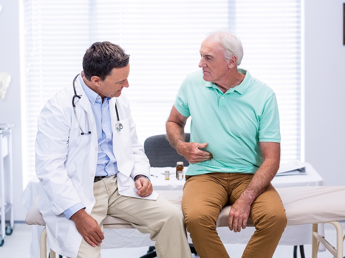Bauchchirurgische Sprechstunde Patient zeigt Arzt schmerzende Stelle am Bauch